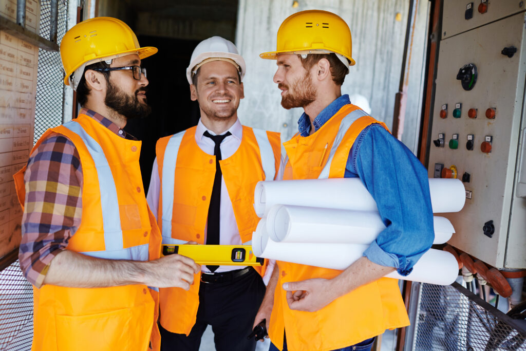 Tres trabajadores del sector de la construcción charlando
